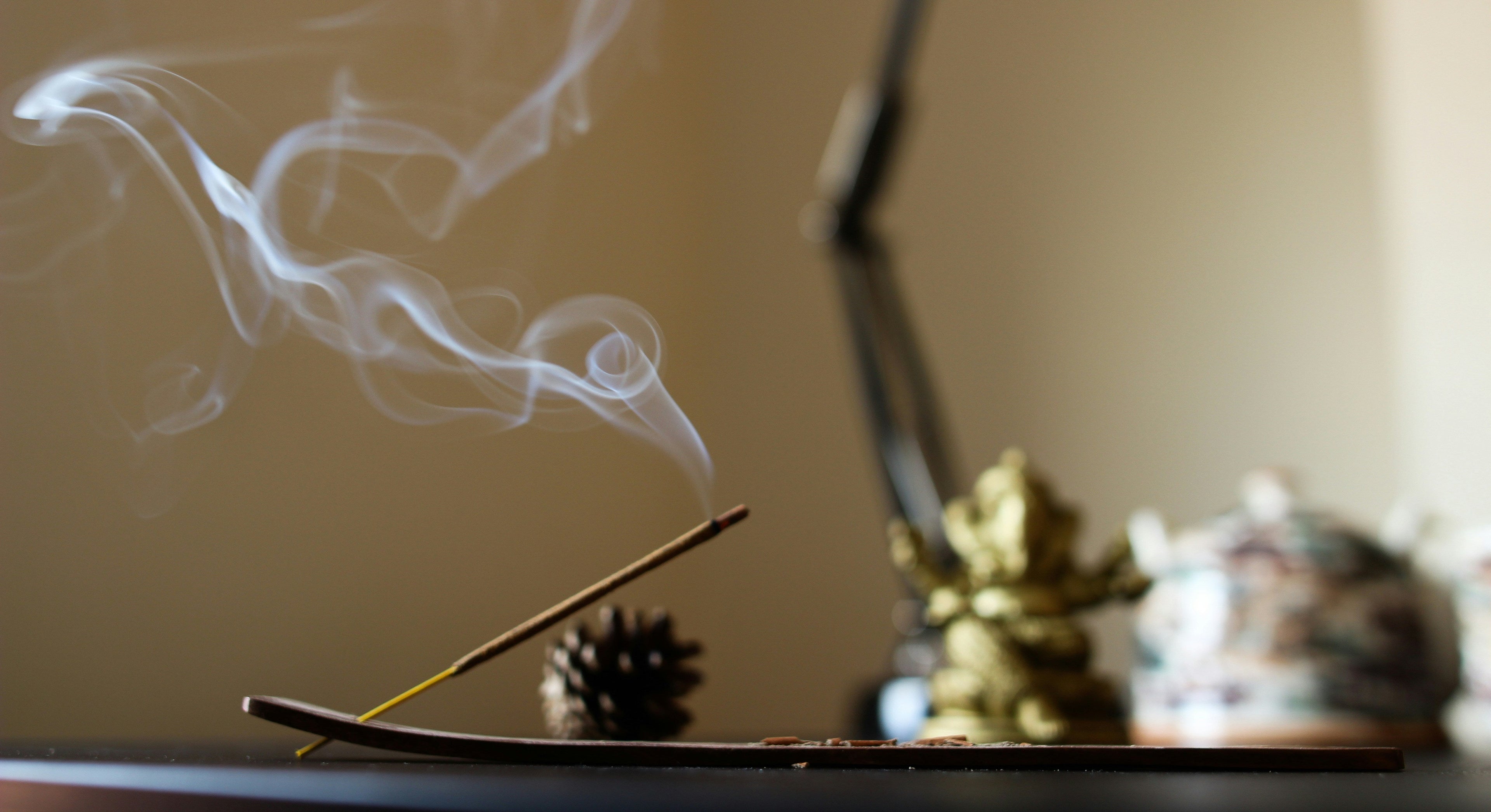 Incense stick with smoke and a blurred background